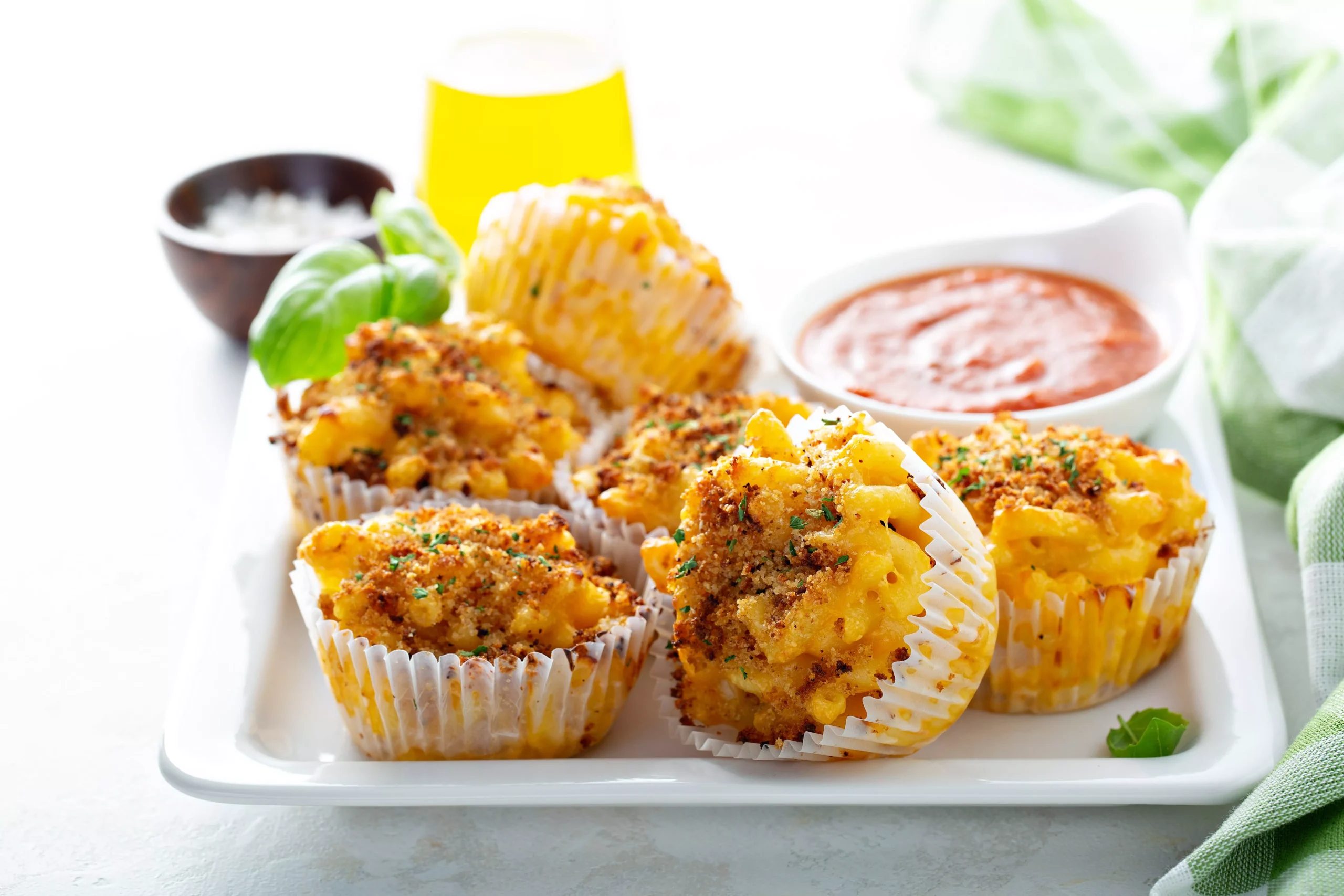 Bite-sized mac and cheese muffins with a crunchy breadcrumb crust, paired with marinara dipping sauce.