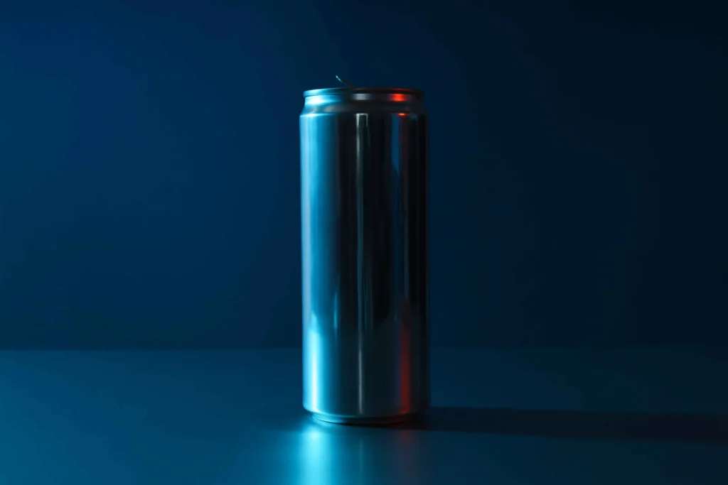 A single unopened beverage can standing on a dark blue surface, illustrating the topic “Can You Drink Red Bull While Pregnant?”